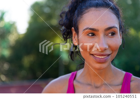 Happy biracial female basketball player wearing pink tshirt at basketball court Happy biracial female basketball player wearing pink tshirt at basketball court 105240551