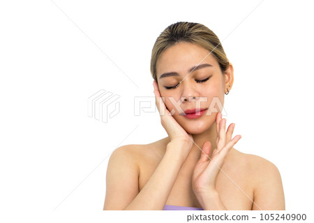 A closeup shot of young woman delicately touching her face, revealing details of her fingers, nails, and facial texture. Her eyes carry an expression of deep contemplation. A closeup shot of young woman delicately touching her face, revealing details of her fingers, nails, and facial texture. Her eyes carry an expression of deep contemplation. 105240900