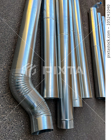 Steel downpipes stacked on the ground. High quality photo Steel downpipes stacked on the ground. High quality photo 105241040