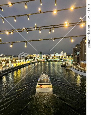 Moscow, Russia - February 8, 2022: The view of river cruise ship and festive lights . High quality photo. Distant view of Kremlin 105241383