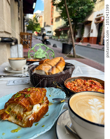 Turkish breakfast with menemen and kaymak croissant on a table of a street cafe. High quality photo 105241399