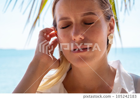 Peaceful lady enjoying the sunshine. Relaxed female spends her free time by ocean. Peaceful lady enjoying the sunshine. Relaxed female spends her free time by ocean. 105242183