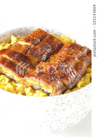 A bowl of kinshi tamago and grilled eel on a white background 105243604