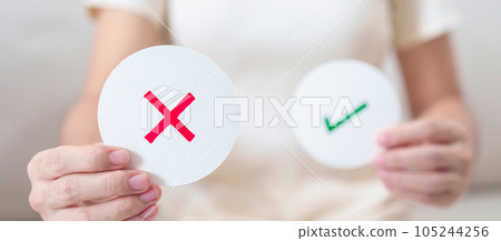 Woman show Wrong symbol paper. True and false, accept and rejected, evaluation, Vote, Poll, Yes or No and Survey concepts 105244256