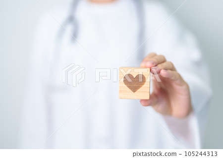 Doctor hand holding heart shape block in hospital. love, donor, world heart day, world health day, CSR donation and Insurance concepts Doctor hand holding heart shape block in hospital. love, donor, world heart day, world health day, CSR donation and Insurance concepts 105244313