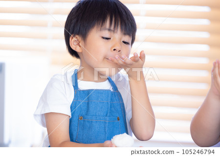 A boy making rice balls with freshly cooked rice A boy making rice balls with freshly cooked rice 105246794