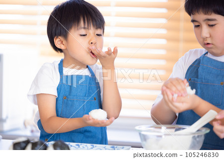 一個男孩用剛煮好的米飯做飯糰 105246830