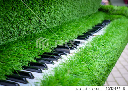 A piano finished with artificial green grass. Piano from the grass. Green thinking. 105247248