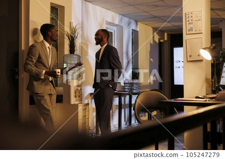 Coworkers discussing project detalies during work break, working at marketing strategy late at night in startup office. Businessmen brainstorming ideas for investment plan. Business concept 105247279