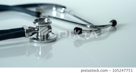 Stethoscope on a white reflective surface. Health care and surgical concept. Stethoscope on a white reflective surface. Health care and surgical concept. 105247751