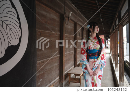 A young woman in a yukata walking through a historic townscape 105248132