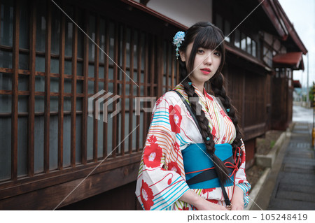 A young woman in a yukata standing in a retro townscape A young woman in a yukata standing in a retro townscape 105248419
