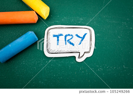 Try. Speech bubble with text and colored pieces of chalk on a green background 105249266