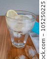 Sparkling water with bubbles in a big transparent glass filled with ice cubes and lemon, a soft plastic form to make ice cubes in the freezer. Solution to overcome extreme high temperature in summer 105250225