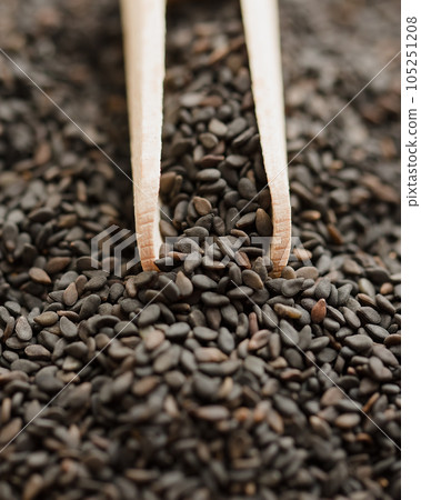 Close up of black sesame seed on wooden spoon background top view. Close up of black sesame seed on wooden spoon background top view. 105251208