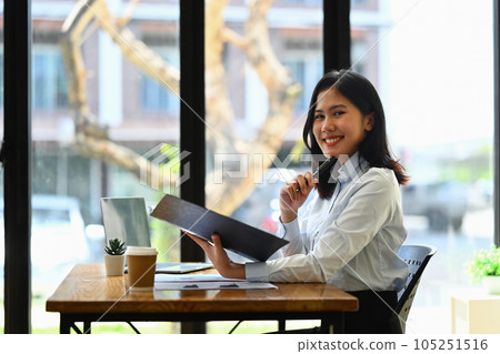 Attractive businesswoman in white shirt working with statistic document at office desk Attractive businesswoman in white shirt working with statistic document at office desk 105251516