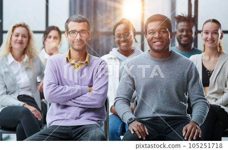 diverse young people sitting on chairs in the conference room. 105251718