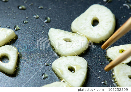 烹飪場景特寫,大蒜(切片)在橄欖油中煎炸。 烹飪場景特寫,大蒜(切片)在橄欖油中煎炸。 105252299