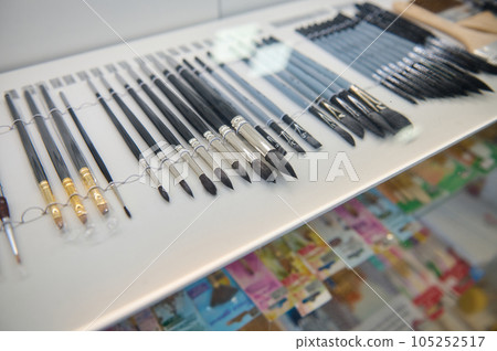 Assortment of paintbrushes and painting tools displayed for sale in school stationery shop. Hobby, leisure, still life 105252517