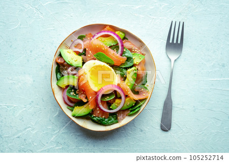 Salmon, avocado and egg salad with fresh leaves and onions, overhead 105252714