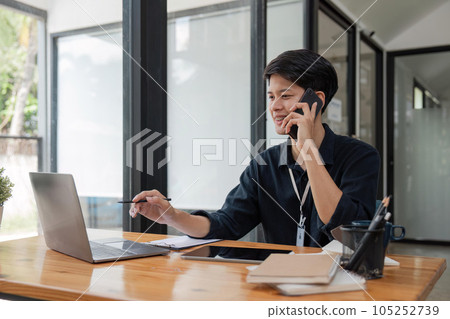 Handsome businessman is talking on the phone in the office Handsome businessman is talking on the phone in the office 105252739
