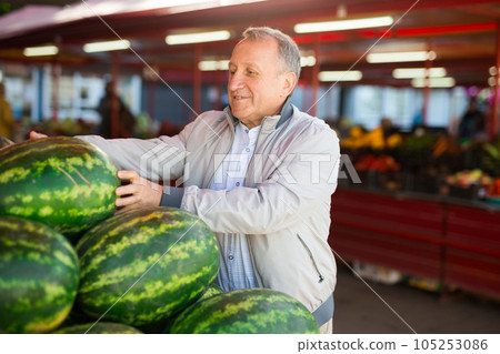 Middle aged man buying watermelon Middle aged man buying watermelon 105253086