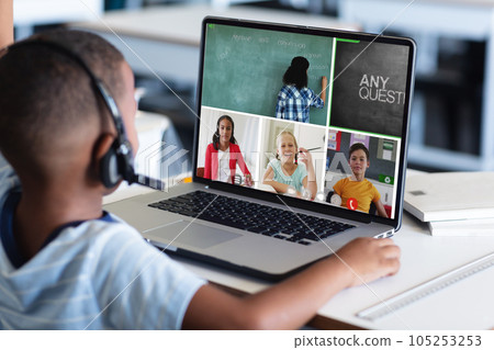 African american boy in headphones and looking at teacher and students during online class on laptop African american boy in headphones and looking at teacher and students during online class on laptop 105253253