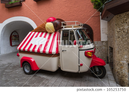 An ice-cream van with red and white stripes, parked on the corner. An ice-cream van with red and white stripes, parked on the corner. 105253750