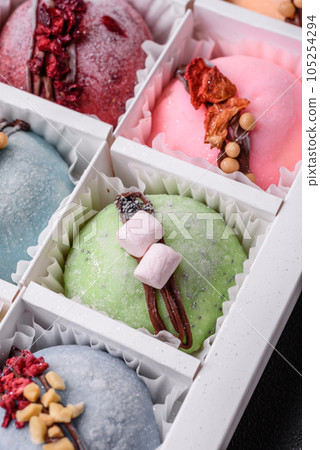 Delicious sweet colorful mochi desserts or ice cream with rice dough and toppings Delicious sweet colorful mochi desserts or ice cream with rice dough and toppings 105254294