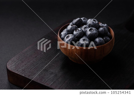 Delicious fresh sweet blueberries in a ceramic bowl. Vegan food Delicious fresh sweet blueberries in a ceramic bowl. Vegan food 105254341