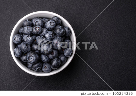 Delicious fresh sweet blueberries in a ceramic bowl. Vegan food Delicious fresh sweet blueberries in a ceramic bowl. Vegan food 105254356