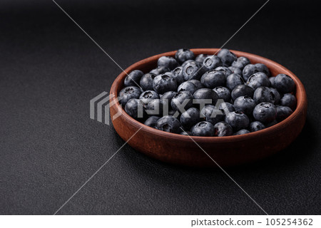 Delicious fresh sweet blueberries in a ceramic bowl. Vegan food Delicious fresh sweet blueberries in a ceramic bowl. Vegan food 105254362