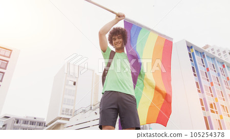 Smiling handsome young man with LGBT flag in his hands 105254378