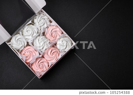 Delicious sweet multi-colored marshmallow on a dark concrete background Delicious sweet multi-colored marshmallow on a dark concrete background 105254388