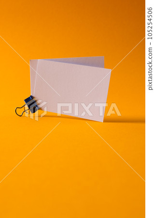 White business cards with paperclip and copy space on orange background 105254506