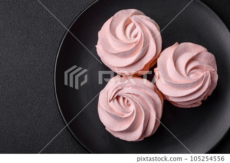Delicious sweet colored marshmallow on a dark concrete background Delicious sweet colored marshmallow on a dark concrete background 105254556