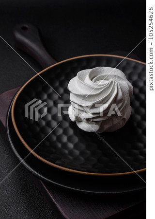 Delicious sweet colored marshmallow on a dark concrete background Delicious sweet colored marshmallow on a dark concrete background 105254628