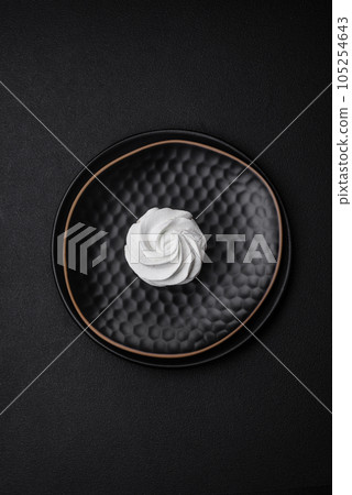 Delicious sweet colored marshmallow on a dark concrete background Delicious sweet colored marshmallow on a dark concrete background 105254643