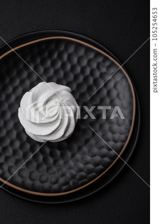 Delicious sweet colored marshmallow on a dark concrete background Delicious sweet colored marshmallow on a dark concrete background 105254653
