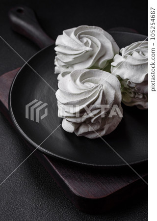 Delicious sweet colored marshmallow on a dark concrete background Delicious sweet colored marshmallow on a dark concrete background 105254687