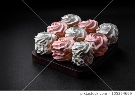 Delicious sweet multi-colored marshmallow on a dark concrete background Delicious sweet multi-colored marshmallow on a dark concrete background 105254699