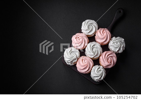 Delicious sweet multi-colored marshmallow on a dark concrete background Delicious sweet multi-colored marshmallow on a dark concrete background 105254702