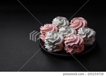 Delicious sweet multi-colored marshmallow on a dark concrete background Delicious sweet multi-colored marshmallow on a dark concrete background 105254739