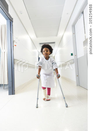 Portrait of african american girl patient walking with crutches in corridor at hospital Portrait of african american girl patient walking with crutches in corridor at hospital 105254988