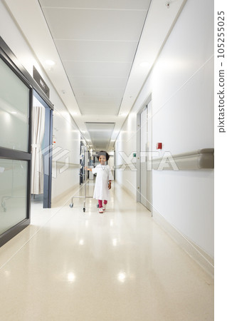 Happy african american girl patient holding drip and walking in corridor at hospital 105255025