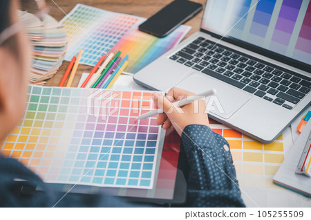 Graphic designer architects who work with laptops and color comparison tables for design work.. 105255509