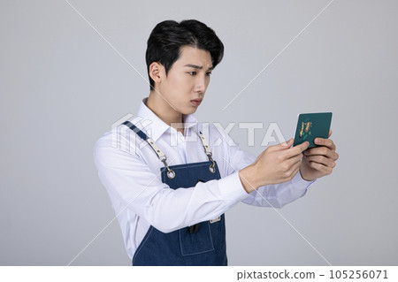 millennials and gen z, korean asian young man struggling with his bankbook 105256071