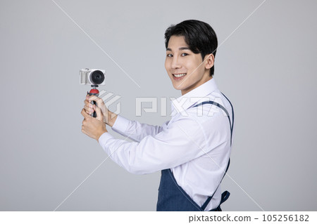 millennials and gen z, korean asian young man filming with a camera 105256182