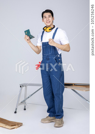 millennials and gen z, korean asian young man carpenter holding a bankbook 105256246