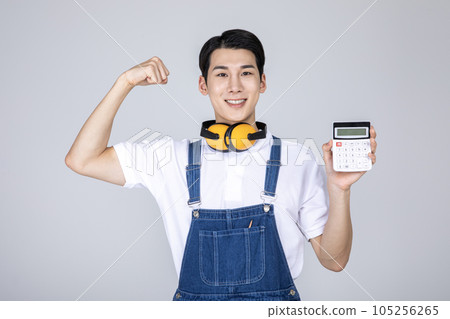 millennials and gen z, korean asian young man carpenter holding a calculator millennials and gen z, korean asian young man carpenter holding a calculator 105256265